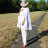 Modern cape styled over a sleek, neutral-toned outfit for a contemporary, fashion-forward look.