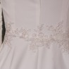Gros plan sur les finitions brodées à la main de la robe de mariée