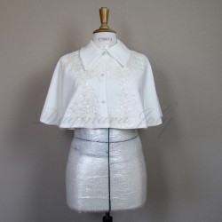 Gros plan sur cape de mariée de couture montrant dentelle brodée à la main, sequins transparents et petits cristaux.