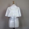 Gros plan sur cape de mariée de couture montrant dentelle brodée à la main, sequins transparents et petits cristaux.