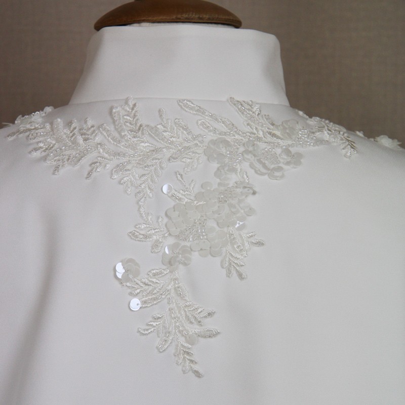 Close-up of ornate hand-decorated details on wedding capelet.