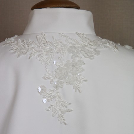 Close-up of ornate hand-decorated details on wedding capelet.
