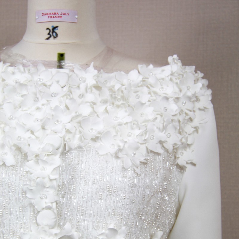 Détail des broderies et perles cousues à la main.