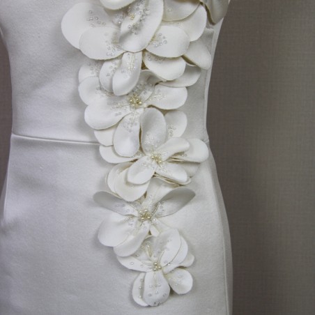 Détail des fleurs en tissu et perles faites main sur la robe de mariée