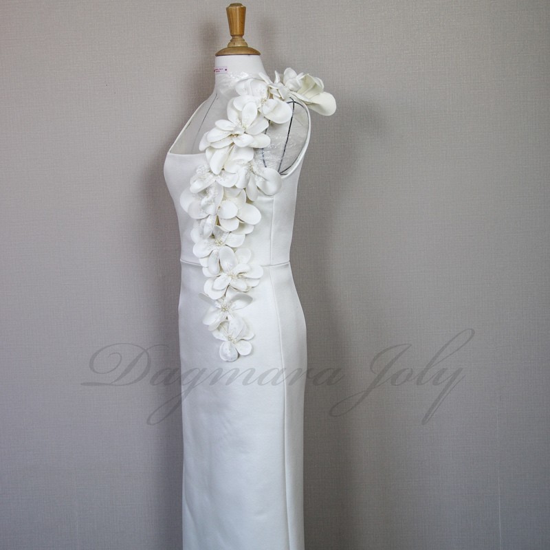 Detailed view of handcrafted fabric flowers and pearls on minimalist French bridal gown