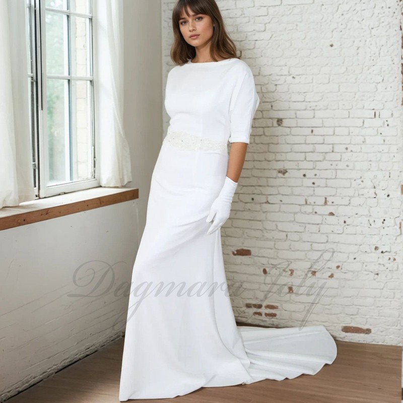 Front view of a floor-length wedding gown with dolman sleeves and a dramatic cathedral train extending gracefully behind Front view of a floor-length wedding gown with dolman sleeves and a dramatic cathedral train extending gracefully behind