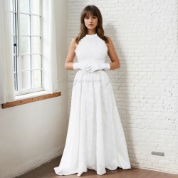 Model in a floor-length cotton halter neck wedding dress with a flowing train, posing