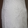 Close-up of hand appliqués of transparent shiny tubes on a lace of wedding dress.