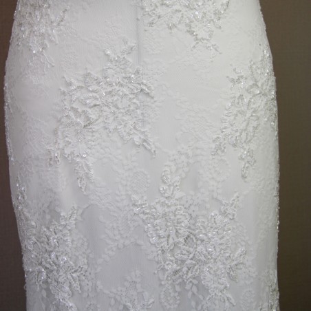 Fine lace texture and delicate embroidery on a modest sheath wedding dress.