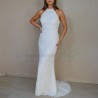 Front view of a minimalist wedding gown with halter neckline and flowing train.