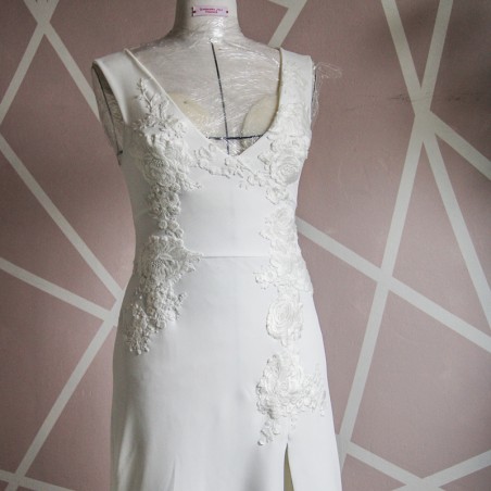 Close-up of V neckline on minimalist crepe bridal gown and lace embellishments