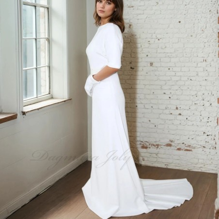 Front view of a floor-length wedding gown with dolman sleeves and cathedral train extending gracefully behind