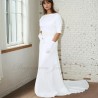 Front view of a floor-length wedding gown with dolman sleeves and cathedral train extending gracefully behind