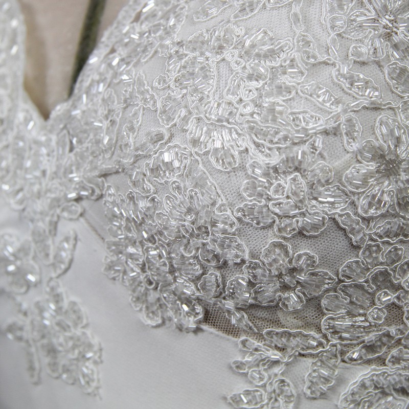 Ornements en dentelle et cristaux sur le devant de la robe de mariée