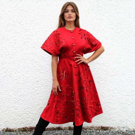Vue de face du manteau rouge en laine pour femme, brodé à la main avec une coupe ajustée.