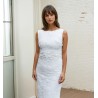 Bride wearing a modest boatneck sheath wedding dress with train, made of delicate guipure lace.