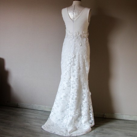 Vue de dos d’une robe de mariée fourreau en dentelle avec traîne courte et col bateau