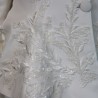 Gros plan sur les broderies couture d’un tailleur de mariée fait main
