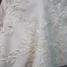 Gros plan sur les broderies couture d’un tailleur de mariée fait main
