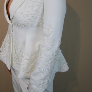 Gros plan sur les broderies couture d’un blazer de mariée fait main