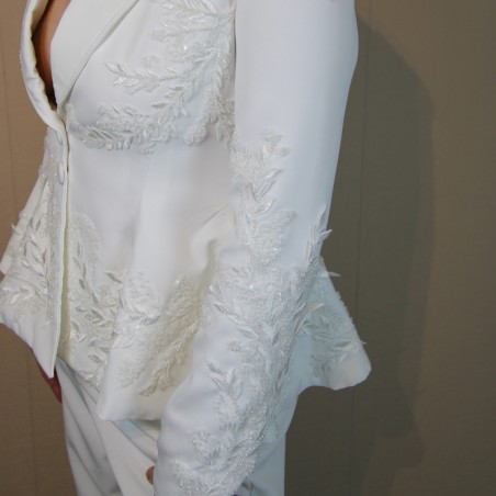 Gros plan sur les broderies couture d’un blazer de mariée fait main