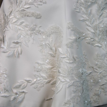 Gros plan sur les broderies couture d’un topper de mariée fait main