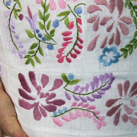 Détail des broderies délicates faites à la main sur le corsage d’une robe de mariée éco-responsable.