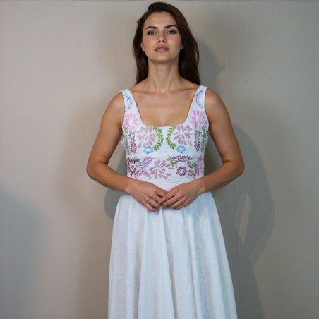 A bride wearing a floor length linen hand embroidered wedding dress standing gracefully