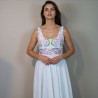 A bride wearing a floor length linen hand embroidered wedding dress standing gracefully