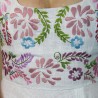 Zoom on colorful embroidered floral motif on linen bridal dress