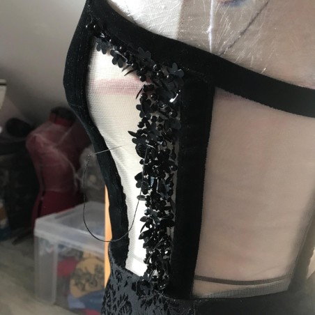 Close-up of hand-beaded details on black velvet dress