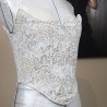 Photo en lumière tamisée soulignant la brillance et la richesse du tissu en brocart de ce corset
