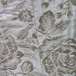Gros plan du tissu en brocart victorien luxueux montrant des broderies et une texture raffinées.