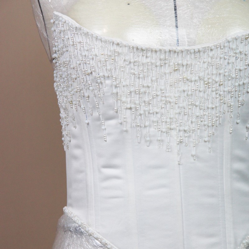 Vue devant du ornement de pierres scintillantes sur corset de mariée, fait sur mesure