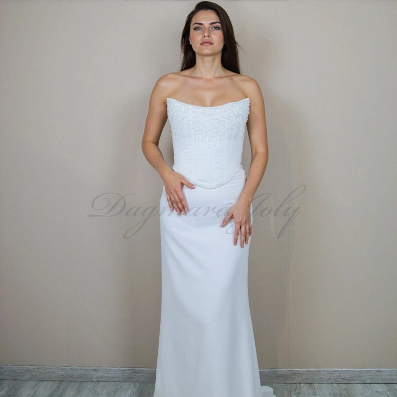Modèle portant le corset de mariée orné de pierres scintillantes avec la jupe avec traîne subtile ajoutent de mouvement élégant