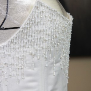 Gros plan du ornement de pierres scintillantes sur corset de mariée, fait sur mesure