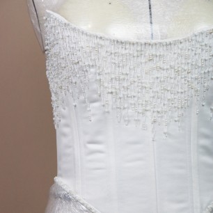 Vue devant du ornement de pierres scintillantes sur corset de mariée, fait sur mesure