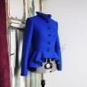 Close-up of pleated collar detail on asymmetrical blue peplum jacket