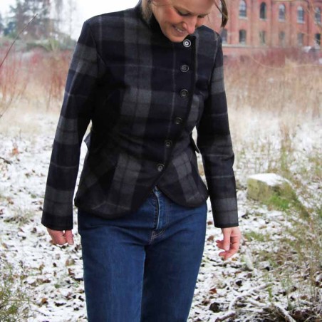 Veste courte plaid de créateur avec silhouette asymétrique et ornements artisanaux uniques.