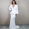 Modern made-to-measure bridal suit in white crepe featuring sculptural peplum jacket and flowing train skirt.
