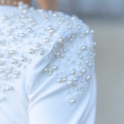 zoom sur les broderies à la main avec perles et cristaux du costume de mariage jupe peplum