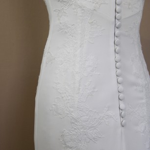 Close-up of hand embellished lace detail on modern crepe wedding gown