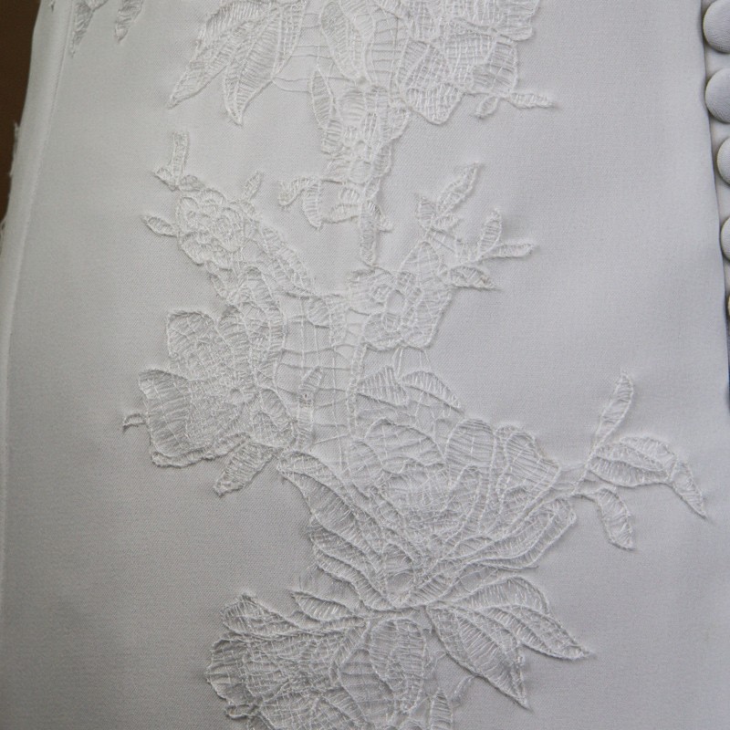 Dentelle et boutons d’une robe de mariée artisanale fabriquée en France