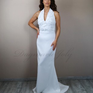 Robe de mariée fourreau en dentelle et crepe avec col licou et traîne, portée par une mariée