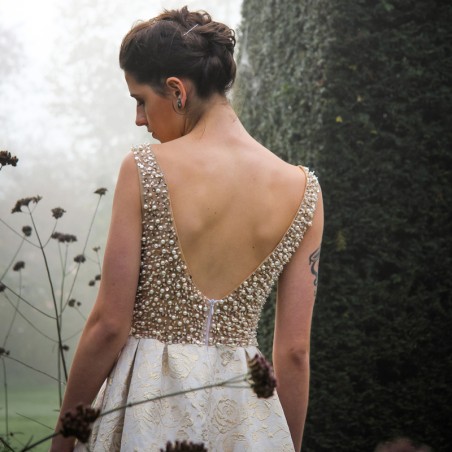 Zoom sur le dos de la robe de mariée couture avec dos ouvert en U et longue traîne