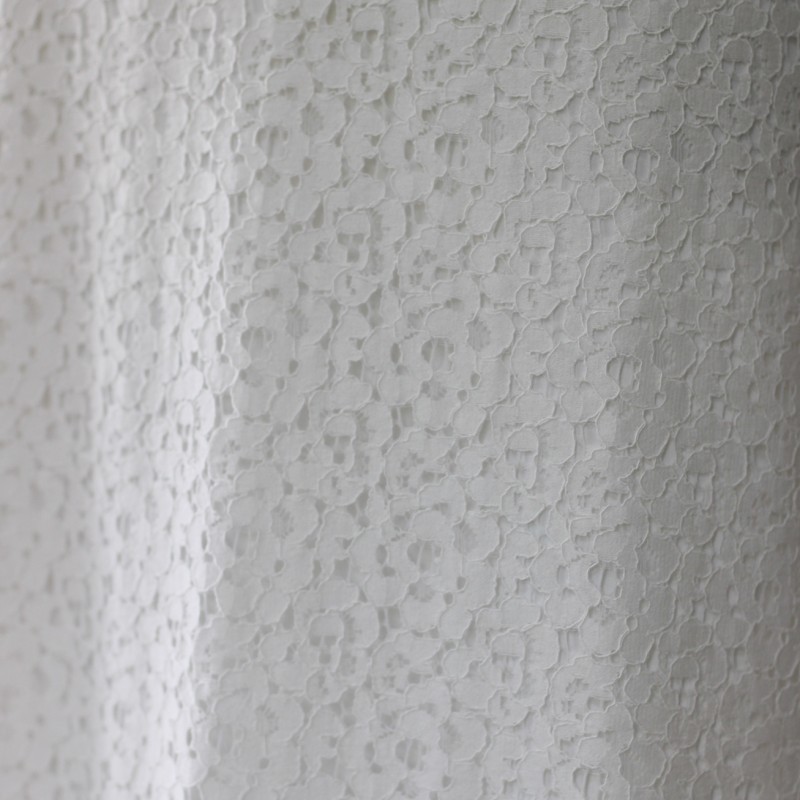 Zoom sur la dentelle sur la robe de mariée trainée