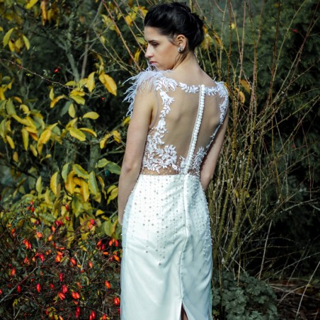 Robe de mariée droite ornée des perles, sans manches, boutonnée dans le dos