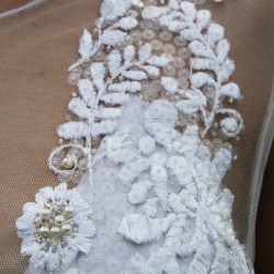 Close-up of the delicate hand-embroidered motifs on the tulle.