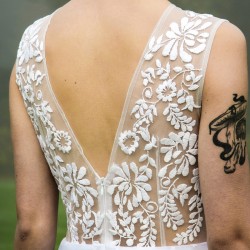 Back view of the dress, showing intricate hand-stitched embroidery and elegant silhouette.
