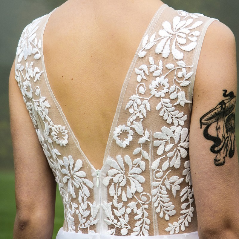 Back view of the dress, showing intricate hand-stitched embroidery and elegant silhouette.